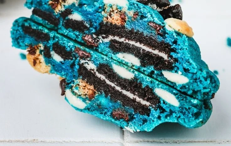 Bakery-style blue cookies fresh out of the oven on a cooling rack.