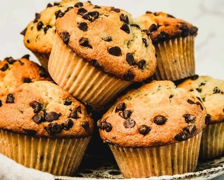 Freshly baked bakery-style chocolate chip muffins on a cooling rack