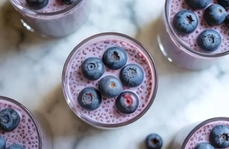 Blueberry chia seed pudding topped with fresh blueberries and a sprig of mint