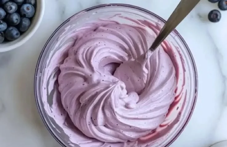 Blueberry cream cheese frosting on a decadent cake slice