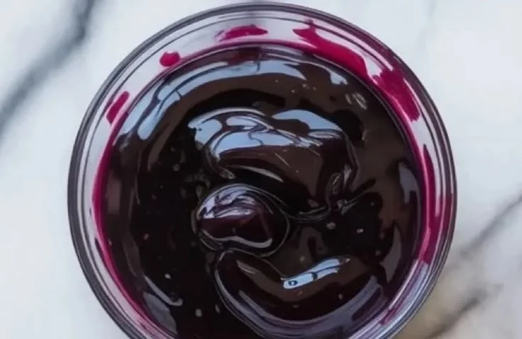 Delicious blueberry curd in a glass jar with fresh blueberries