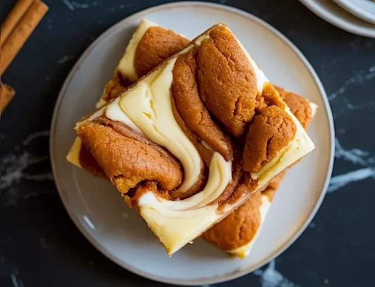 Cheesecake Swirl Snickerdoodle Bars displayed on a plate