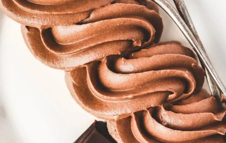 Delicious homemade chocolate buttercream frosting spread on a cake