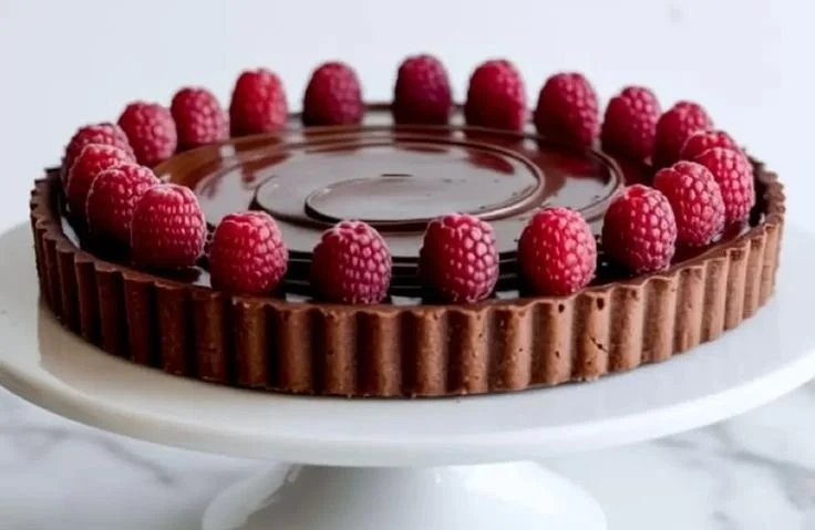 Delicious Chocolate Raspberry Tart topped with fresh raspberries and chocolate.