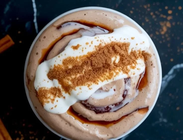 Cinnamon roll smoothie bowl topped with nuts and fruits for a healthy treat