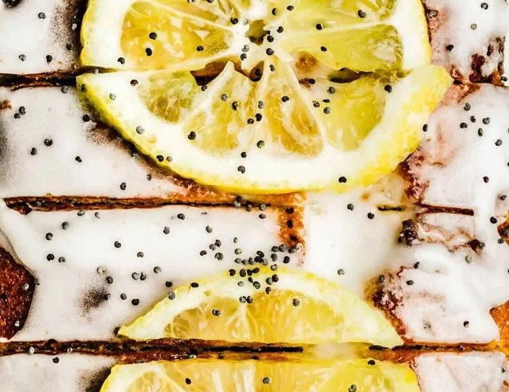 Sliced easy lemon poppy seed cake garnished with lemon zest and poppy seeds