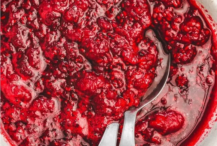 Delicious homemade raspberry filling spread on a cake layer.