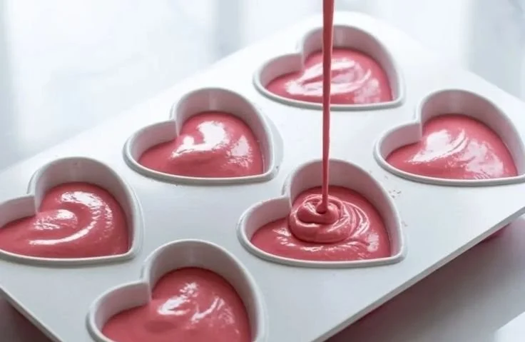 Heart-shaped raspberry mousse dessert with fresh raspberries on top