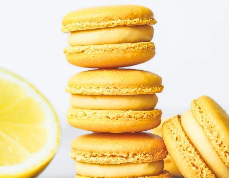 Plate of fresh lemon macarons with a vibrant yellow color