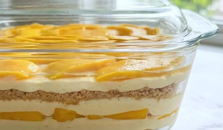 Delicious Mango Float dessert topped with fresh mango slices and whipped cream.