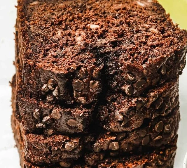 Freshly baked moist chocolate banana bread sliced on a wooden board