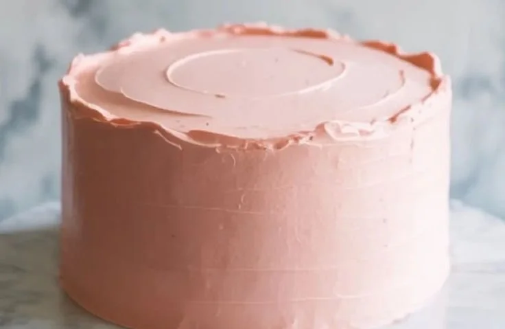 A stunning Pink Champagne Cake decorated with frostings and edible flowers.