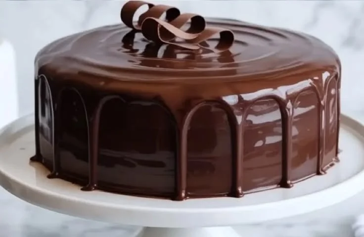 Delicious sour cream chocolate cake topped with chocolate icing and decorations.