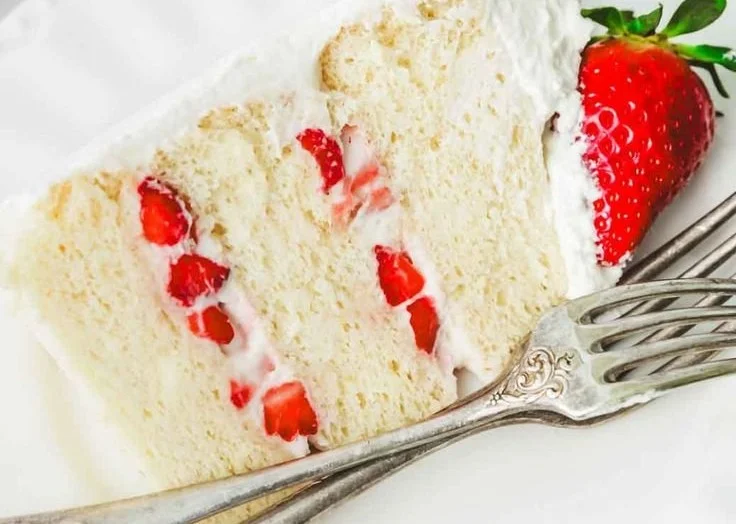 Delicious strawberry birthday cake with fresh strawberries and whipped cream topping.