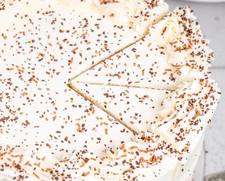 Delicious homemade vanilla cake with frosting and fresh berries on top