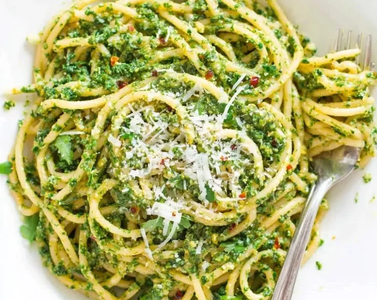 Bowl of homemade Arugula Basil Pesto with fresh herbs and ingredients