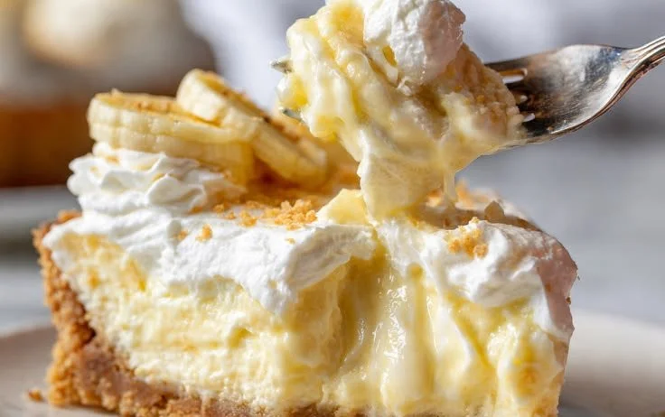 Delicious banana pudding cheesecake served with a creamy topping and banana slices