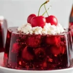 Delicious Cherry Coke Jello dessert served in a clear bowl.