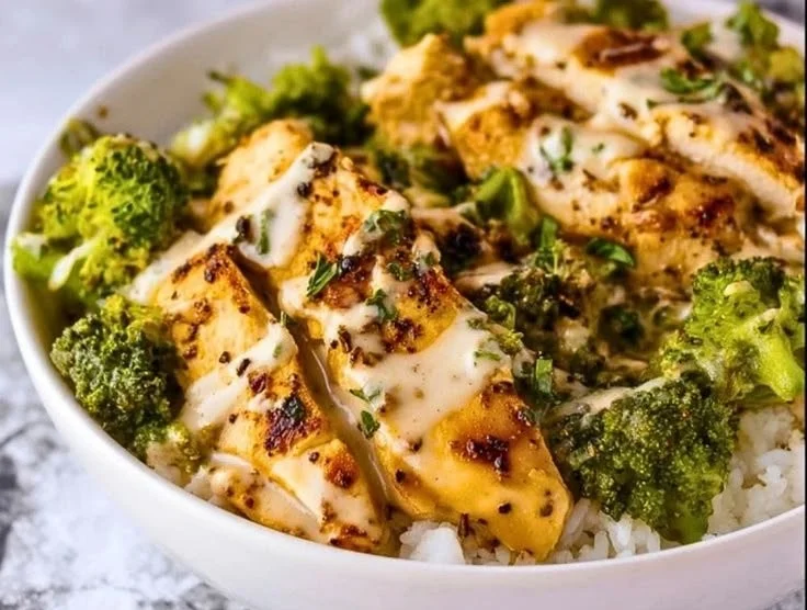 Creamy garlic chicken served in a bowl with fresh broccoli and herbs.