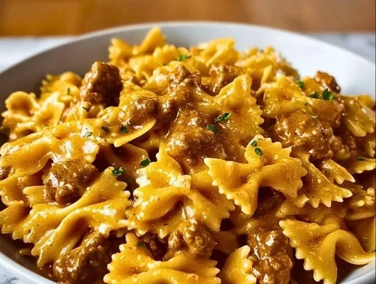 Creamy beef bow tie pasta with Velveeta sauce served in a bowl