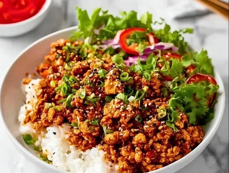 Delicious firecracker ground chicken bowls garnished with fresh vegetables