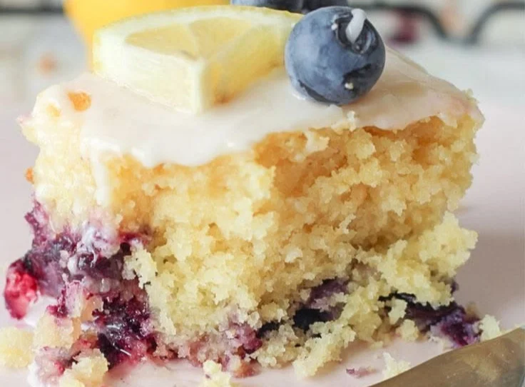 Slice of delicious Lemon Blueberry Sheet Cake with lemon zest and fresh blueberries