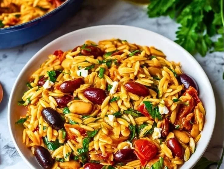 Mediterranean Orzo and Beans dish garnished with herbs and fresh vegetables