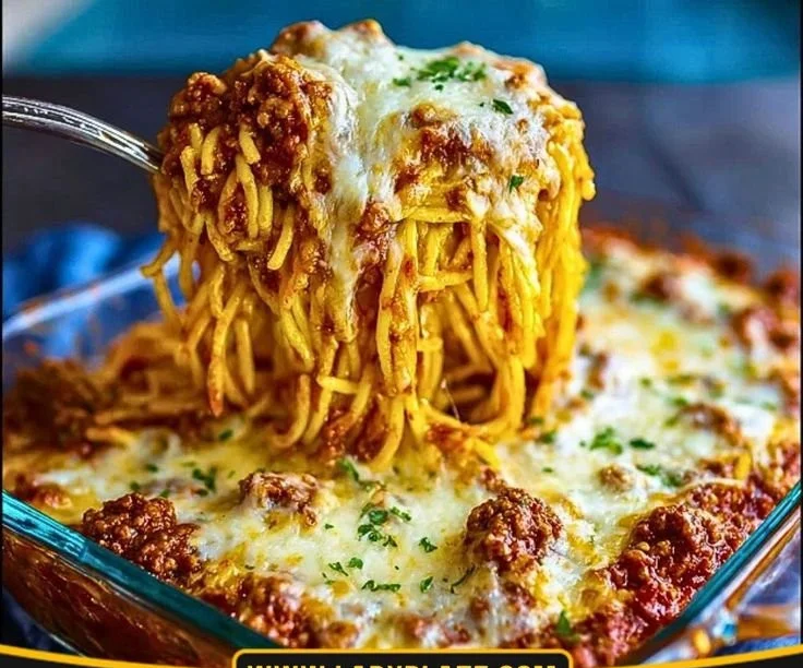 Delicious Million Dollar Spaghetti Bake served in a dish, topped with cheese and herbs.