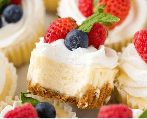 Delicious mini cheesecakes in cupcake liners topped with fresh berries.