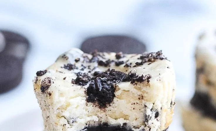 Mini Oreo cheesecakes topped with whipped cream and crushed Oreos