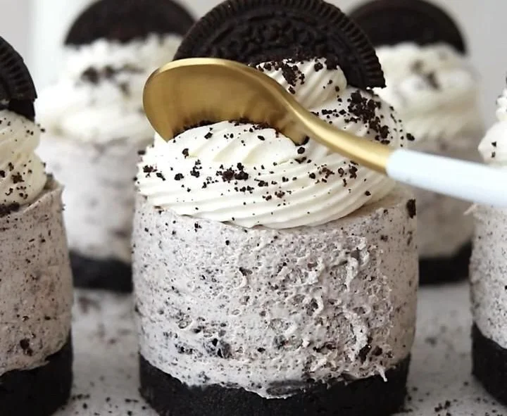 Delicious no-bake Oreo cheesecakes topped with crushed Oreos and chocolate sauce.