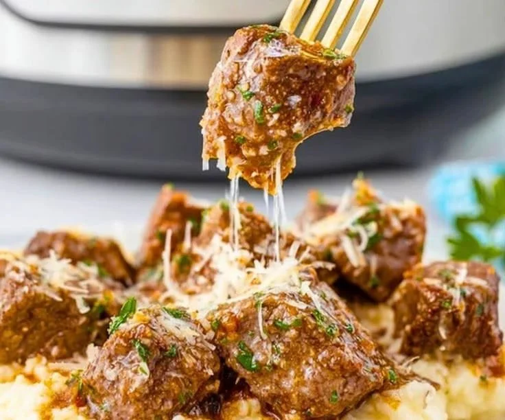 Slow cooker garlic parmesan steak bites garnished with parsley
