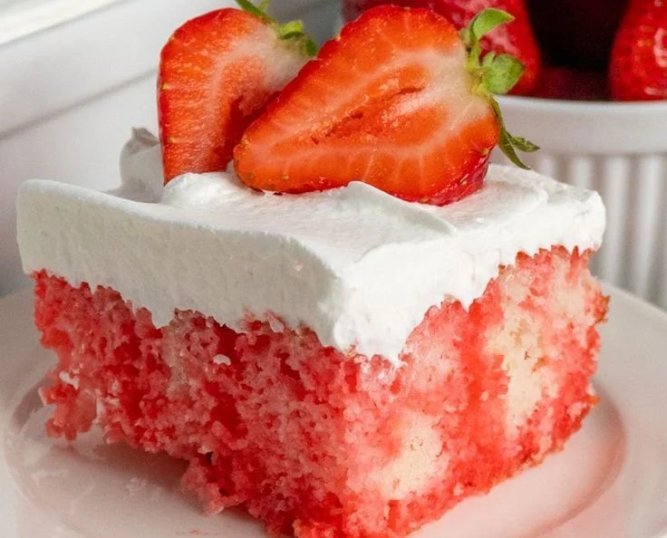 Delicious strawberry poke cake topped with fresh strawberries and whipped cream