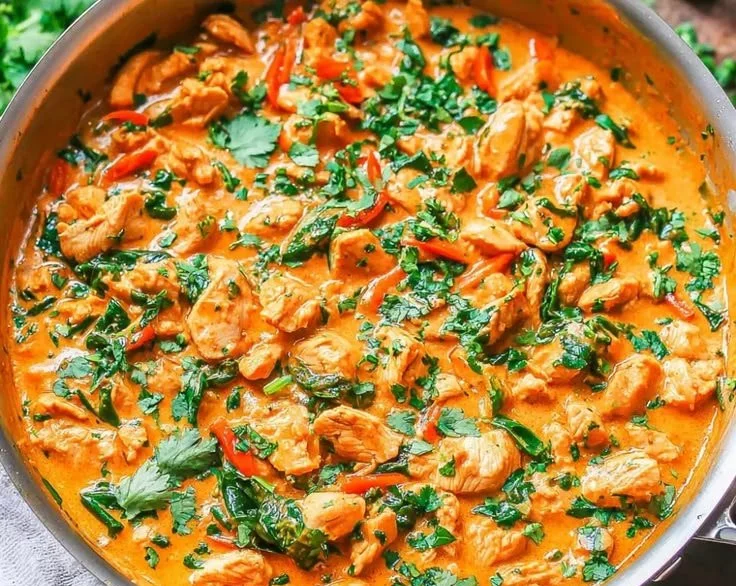 Bowl of delicious Thai Coconut Chicken Curry garnished with fresh herbs