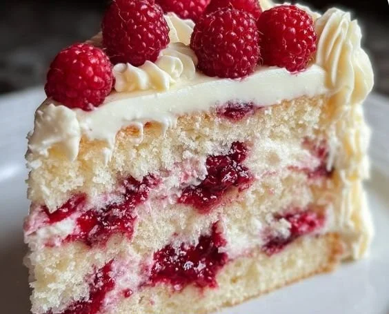 Delicious white chocolate raspberry dream cake with fresh raspberries on top.