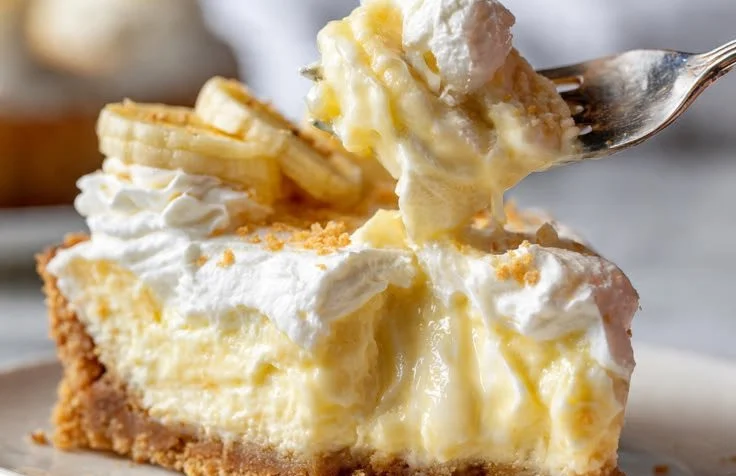 Delicious banana pudding cheesecake topped with whipped cream and banana slices